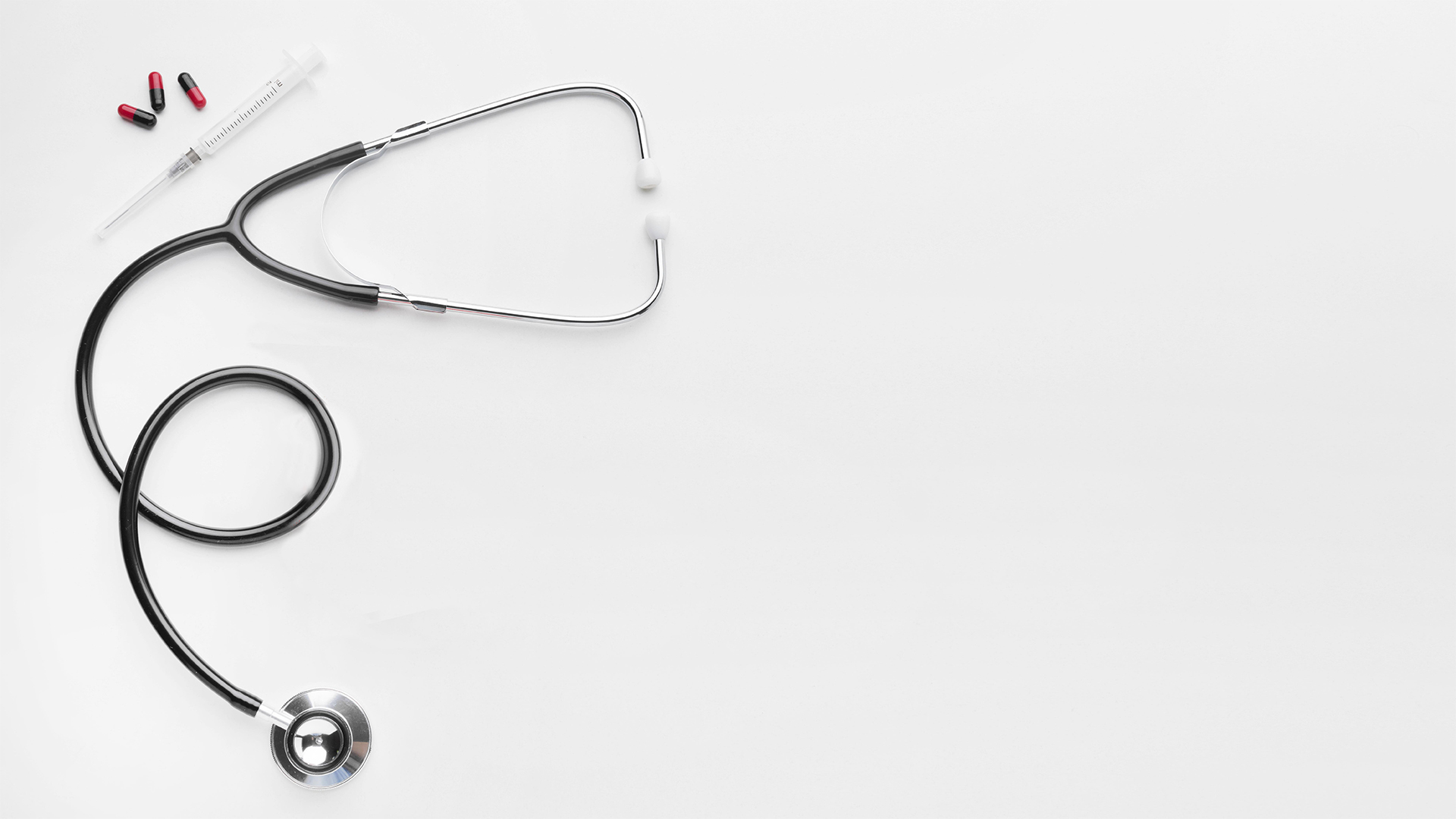 Medizinisches Stethoskop und Gesundheitsutensilien auf weißem Hintergrund